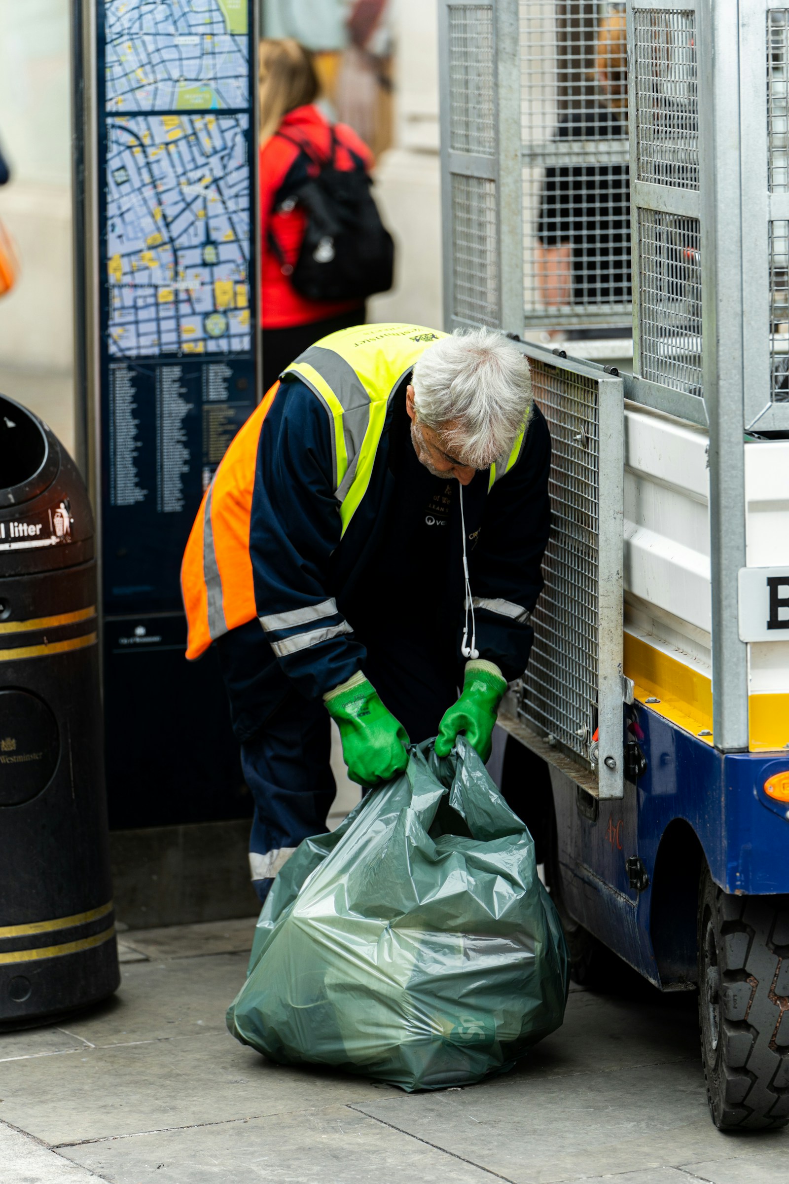 Worker wearing gloves handling a rubbish bag during a clearance job