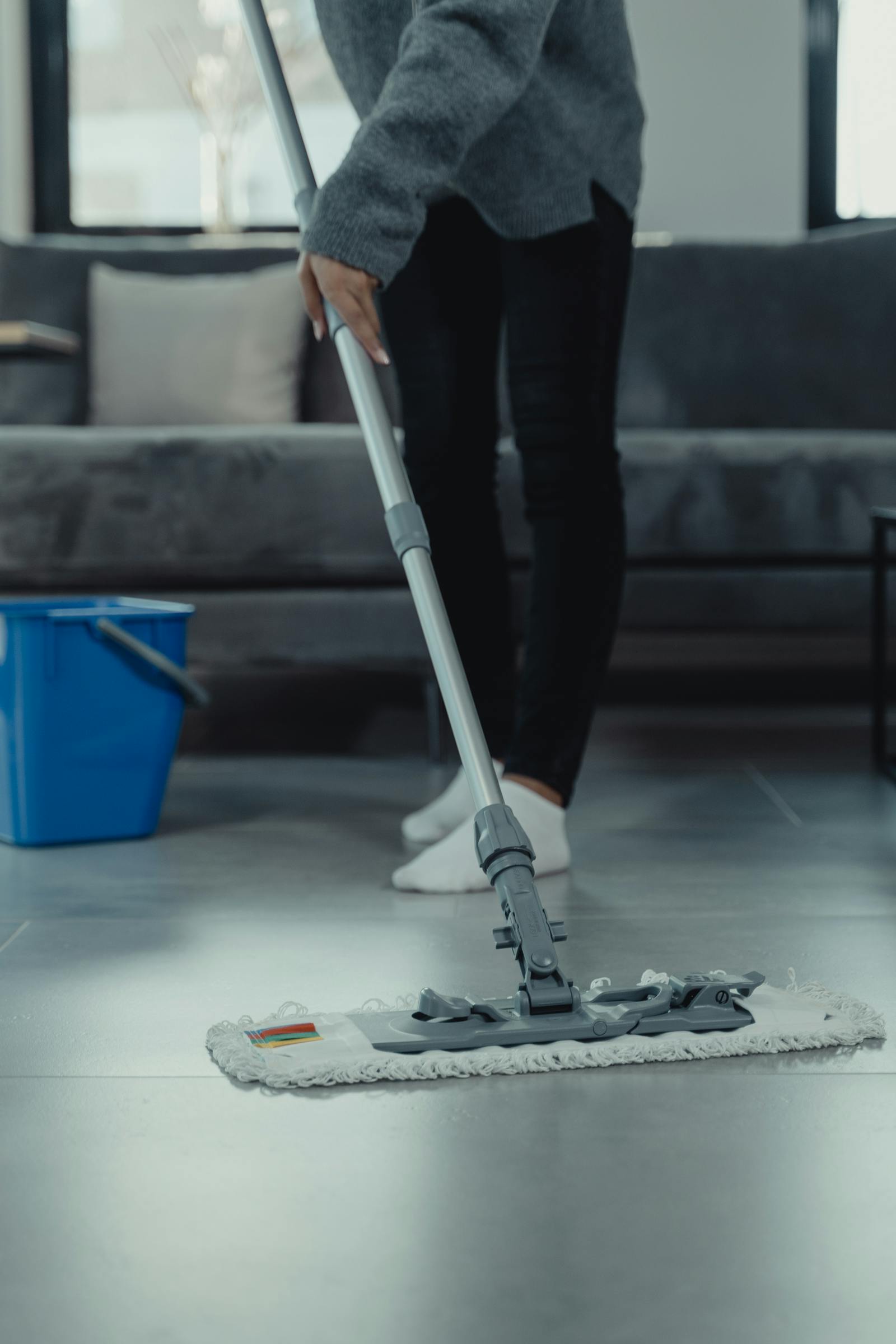 Person mopping a clean modern living room floor