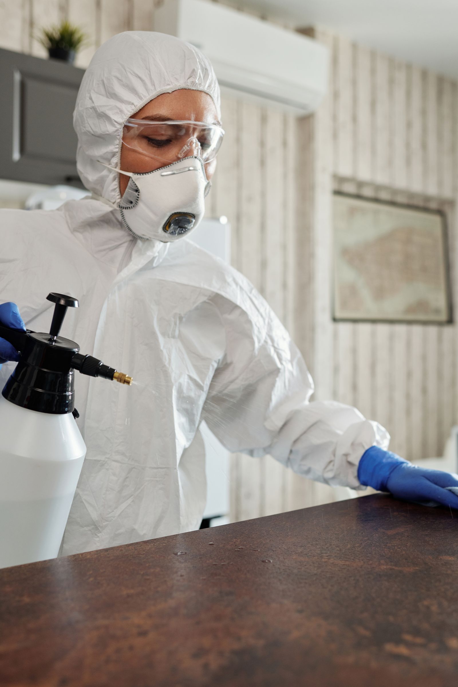 Cleaner in protective clothing preparing for specialist biohazard cleaning